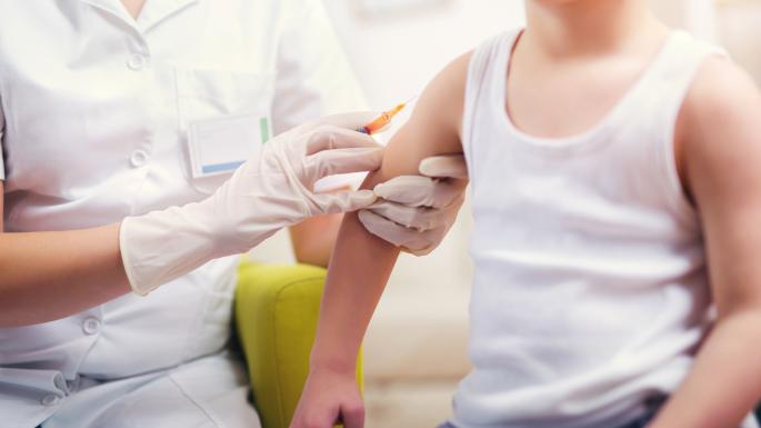 A pediatrician gives a vaccination to a young boy
